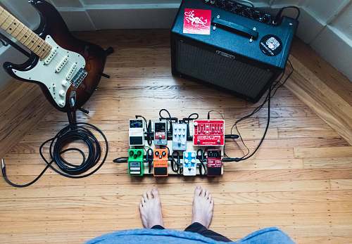 electric guitar assorted guitar pedal lot beside electric guitar and amplifie guitar